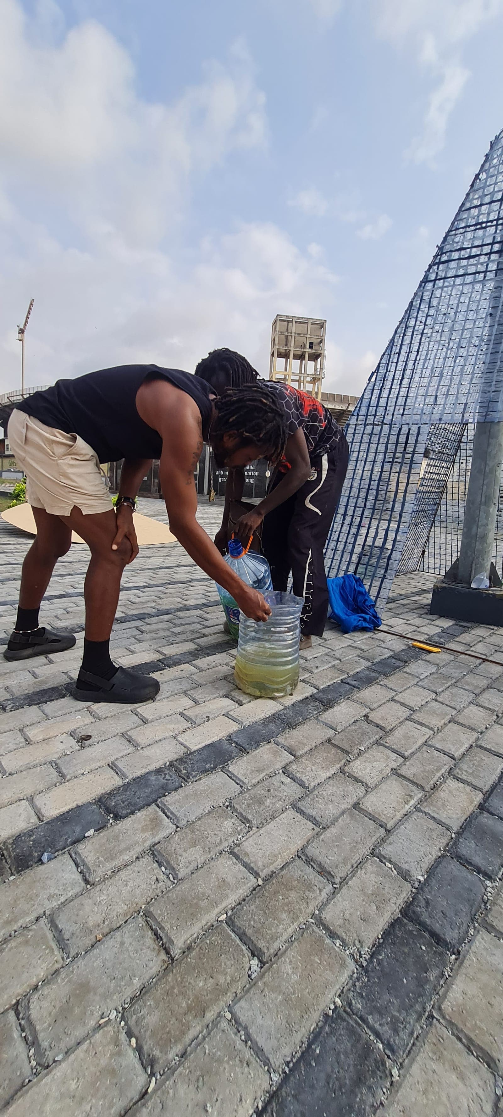 Packing salvaged plastic into cut bottles